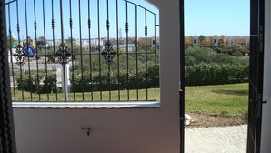A view from a balcony with a metal gate, a tiled floor, and a clear sky. - Impressive in Ground Floor With Terrace of 2 Rooms and Pool (Vera)