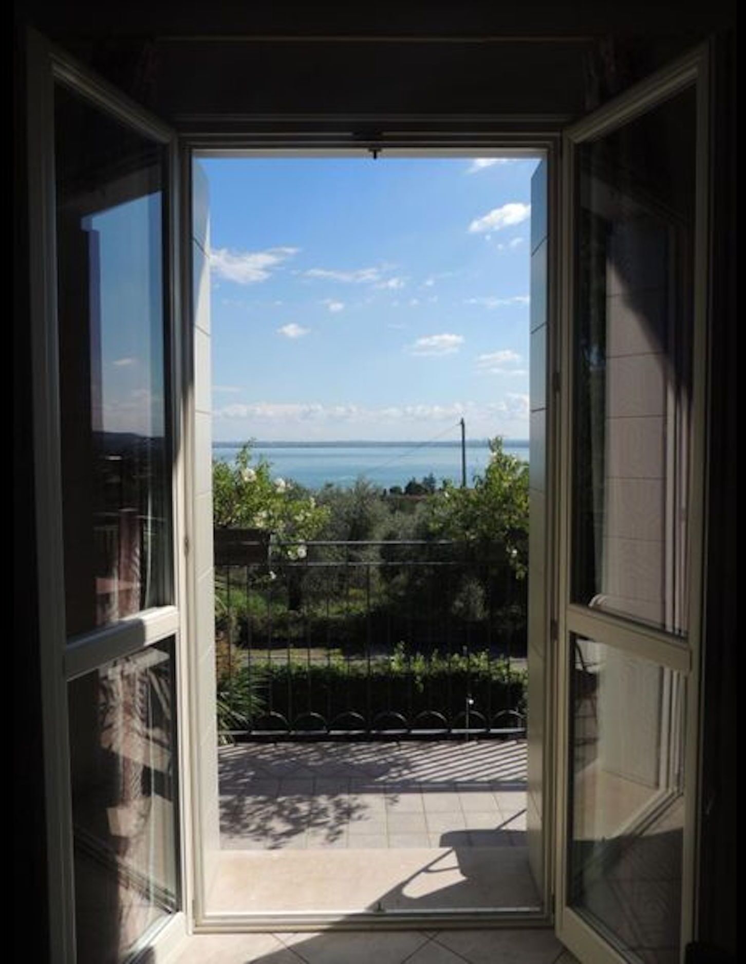 Une vue depuis un balcon, avec un ciel dégagé et un horizon lointain.