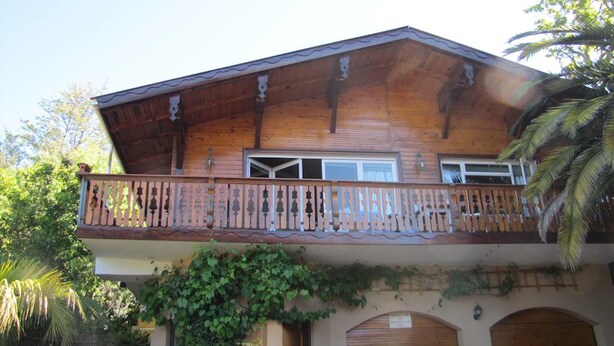 A wooden house with a balcony, a garage, and a covered entrance. - Homely Falt in the Cape Town for 2 (Cape Town)