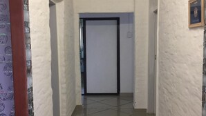 A hallway with white walls and a tiled floor leading to a door. - Room in House - Patzerella's Cozy Nest (Krugersdorp)