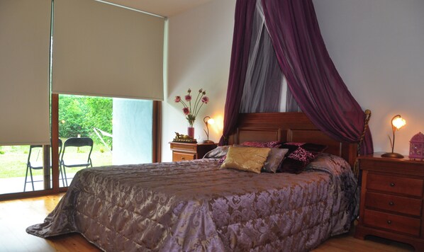 A bedroom with a bed, a nightstand, a lamp, and a window with a view of greenery. - Room-paradise is Real at Vale Martinho S (Santa Comba Dao)