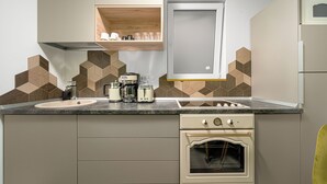 A kitchen with a double sink, a built-in oven, and a coffee maker. - Amazon Apartment - Cismigiu Gardens for 2 Guests (Bucharest)
