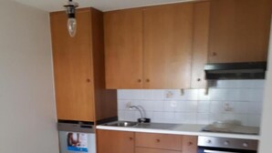 A kitchen with wooden cabinets, a stainless steel sink, and a built-in oven. - Appartamenti La Bettola Chez Patty (Castel San Pietro)
