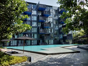 A modern building with balconies and a swimming pool.