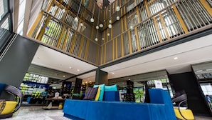 A spacious lobby with a high ceiling, a blue sofa with cushions, and a modern design. - Welcome to the Best and new Apartment to Have Great Trip in Patong Beach (Patong)