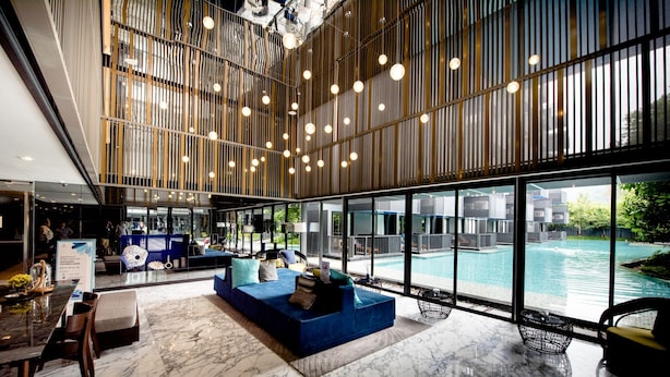 A spacious lobby with a marble floor, a blue seating area, and a large pool visible through the glass walls. - Welcome to the Best and new Apartment to Have Great Trip in Patong Beach (Patong)