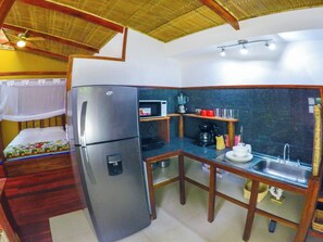 A compact kitchen with a refrigerator, microwave, coffee maker, and sink. - Villa # 3 - High End Studio Apartment With Kitchen, Playa Chiquita (Cahuita)