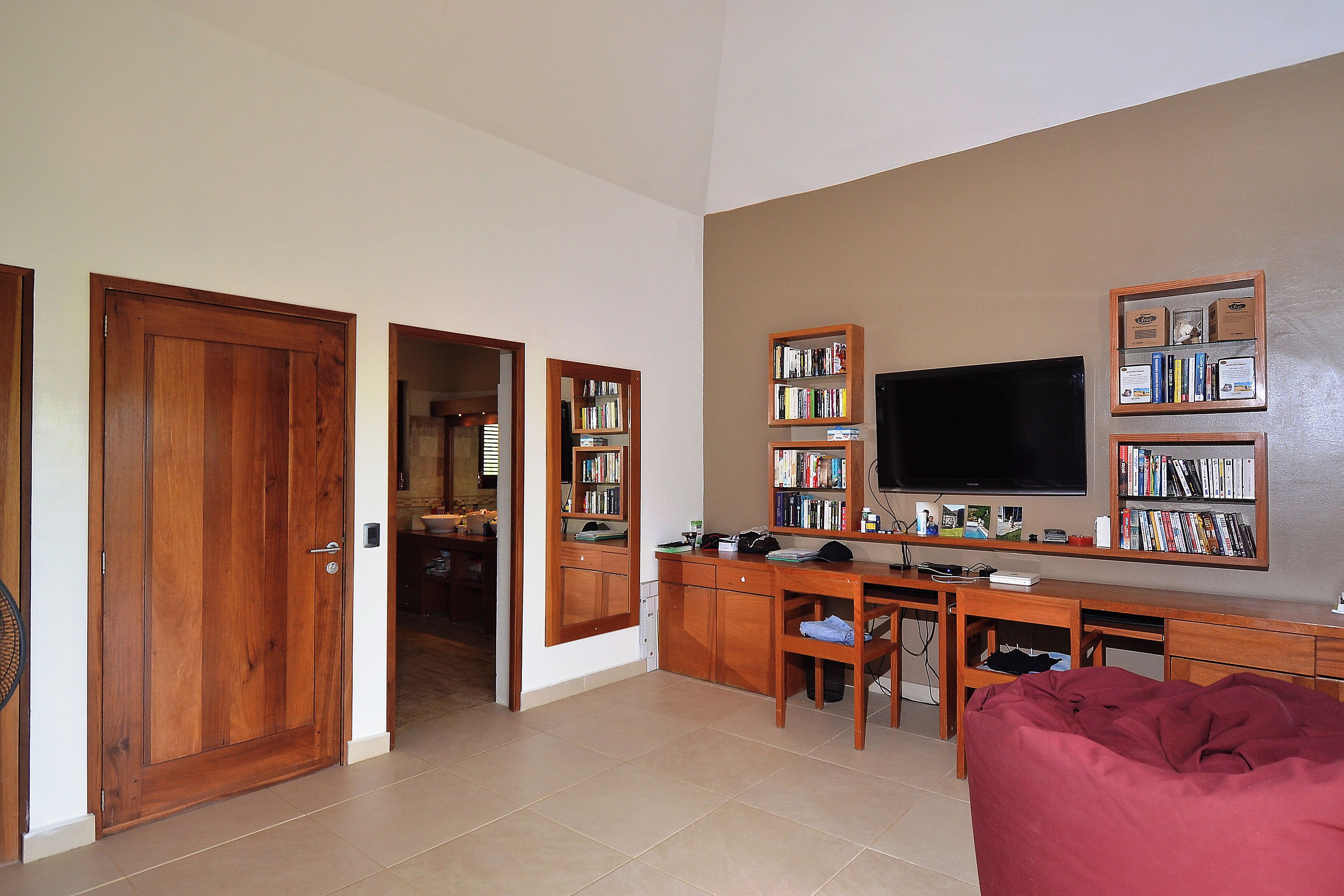 Amplia sala de estar con un televisor grande, muebles de madera y estanterías.