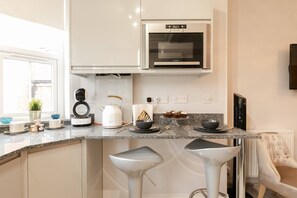 Enjoy casual dining in this kitchen with a microwave, stainless steel range hood, and granite countertop.