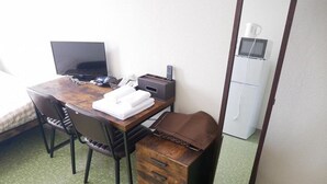 Ein kleiner Raum mit einem Holztisch, einem Laptop, einem Drucker und einer kleinen Ablage.