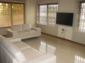 Relax in this stylish living room with a comfortable sofa and large flat-screen TV.