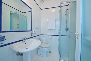 A bathroom with a glass shower enclosure, a white sink, and a toilet. - Villa Panorama Sea View (Furore)