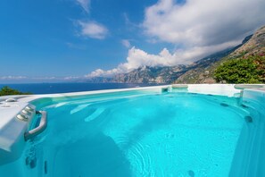 A hot tub with a clear view of the ocean and mountains in the background. - Villa Panorama Sea View (Furore)