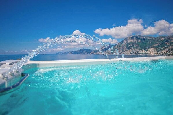 A pool with clear water, a view of the sea, and mountains in the background. - Villa Panorama Sea View (Furore)
