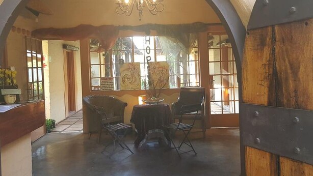 Una habitación acogedora con un techo alto en arco, una araña y una mesa con sillas.