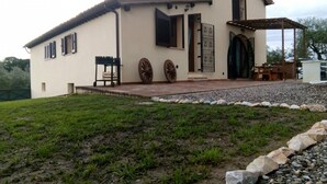 A two-story house with a patio, a large wheel, and a gate. - Villa Degli Olivi Siena (Siena)