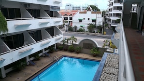A rooftop pool area with a clear blue pool, lounge chairs, and potted plants. - 201 Jomtien Hill Resort Sudio (Pattaya)