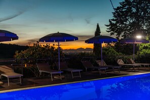 A poolside area with lounge chairs and umbrellas, overlooking a sunset view. - Bb La Mortella With Pool (Roccadaspide)