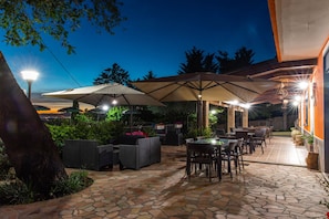 An outdoor patio area with stone flooring, outdoor furniture, and umbrellas providing shade. - Bb La Mortella With Pool (Roccadaspide)