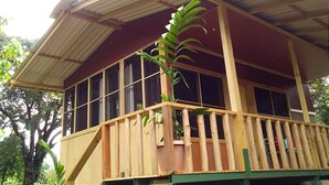 Un edificio in legno con un balcone, ampie finestre e una pianta in vaso.