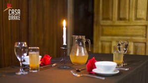 Una tavola apparecchiata con una brocca, bicchieri e una candela, che evoca un'atmosfera romantica o intima per la cena.