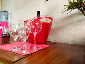 A table with wine glasses and a red bucket, possibly for wine storage.