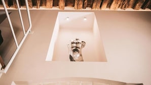 Una bañera de diseño único, techo de madera y baranda de metal.