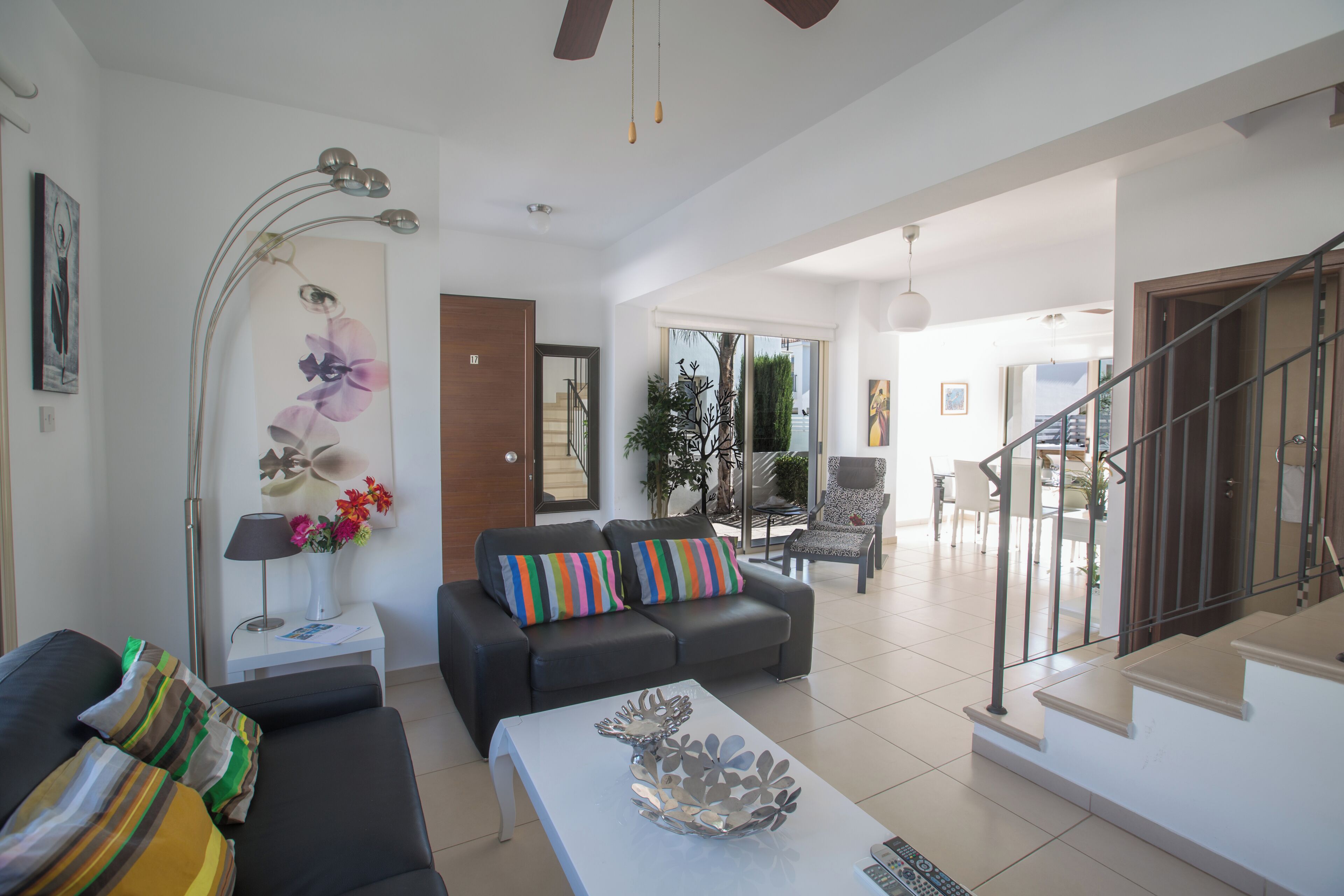 A modern living room with a sofa, a coffee table, and a staircase leading to an upper level.