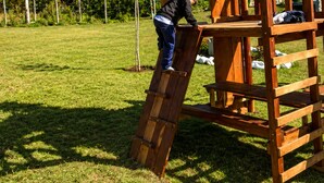 Une structure de jeu en bois, dotée d’une échelle d’escalade et d’une plateforme.