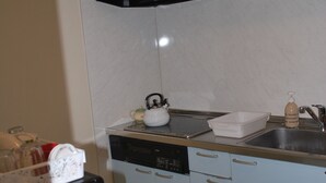 A compact kitchen with a microwave, kettle, and sink. - Apartment A at Asahikawa City (Asahikawa)