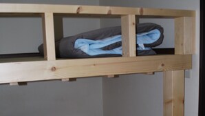 A bunk bed with a mattress on the lower bunk and folded clothes on the upper bunk. - Apartment A at Asahikawa City (Asahikawa)