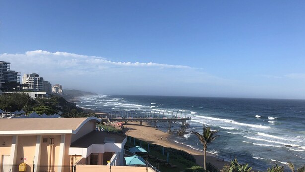 A coastal view with a beach, ocean waves, and a pier. - Casa Villa Guest House Carletonville - Suite 4 (Merafong City)