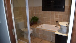 Un baño con inodoro, bañera y lavamanos.