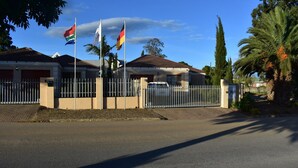Zona residencial cerrada con casas, palmeras y banderas.