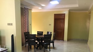 Un espace repas comprenant une table et des chaises, un téléviseur et un haut-parleur.