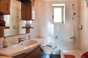 Une salle de bain avec un lavabo, des toilettes et une douche.