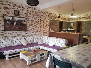 Una sala de estar con sofá, mesa de centro, comedor y área de cocina.