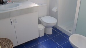 A bathroom with a white sink, toilet, and shower. - Harbour 332 in Puerto De Mogan (Mogan)