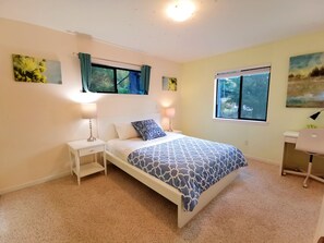 A bedroom with a bed, nightstands, a desk, and two windows with curtains. - Nature House3 Rooms (Issaquah)