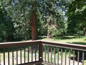 A wooden deck with a view of a forested area. - Nature House3 Rooms (Issaquah)
