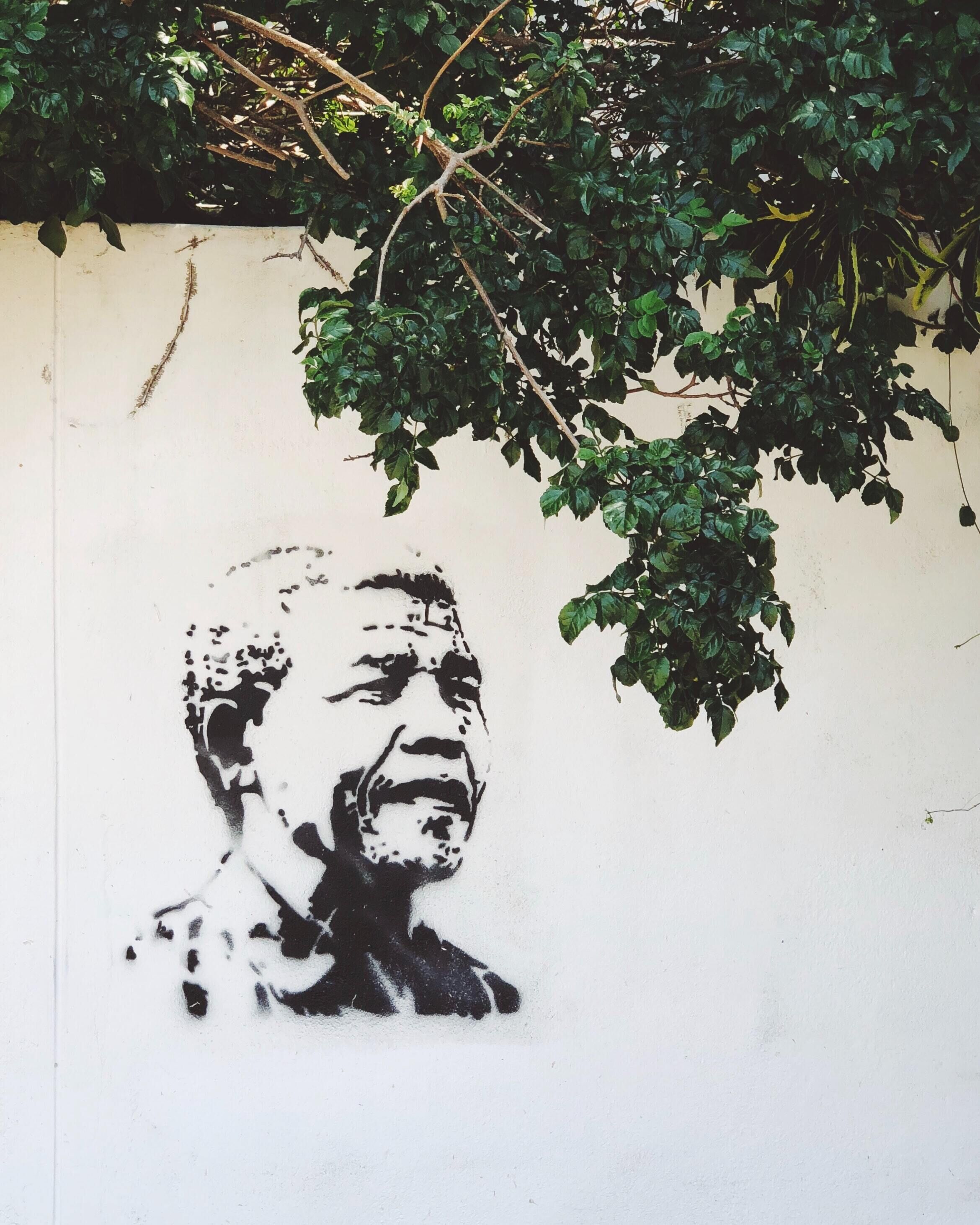 A wall with a black and white mural of a person.