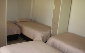 Ein Schlafzimmer mit zwei Einzelbetten und einem Kleiderschrank.