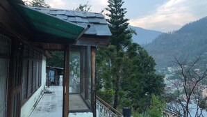 A traditional building with a balcony overlooking a mountainous landscape. - Luxury Private Villa with Mountain View (Banjar)