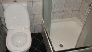 Ein Badezimmer mit Toilette und Duschkabine.