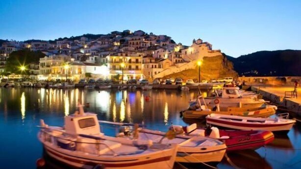 A harbor with boats, a castle-like building, and a town with illuminated buildings. - Villa Yiannoula With Amazing sea View at Skopelos Old Port !!! (Skopelos)