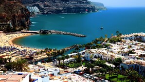 A coastal town with a beach, a rocky cliff, and a marina. - Harbour 374 With Private Roof Terrace in Puerto de Mogan (Mogan)