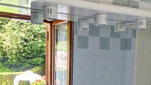 A bathroom with a window, a radiator, a sink, and a toilet. - Molvenolago Apartment (Molveno)
