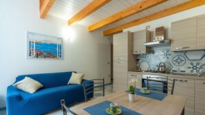 Una cocina moderna con armarios de madera, salpicadero de azulejos y comedor con una mesa y sillas azules.