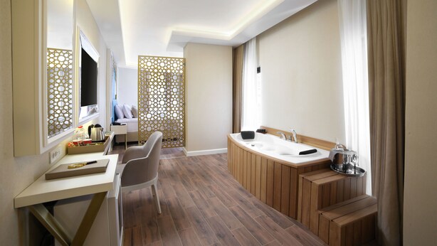 A modern bathroom with a wooden vanity, a large bathtub, and a shower area.