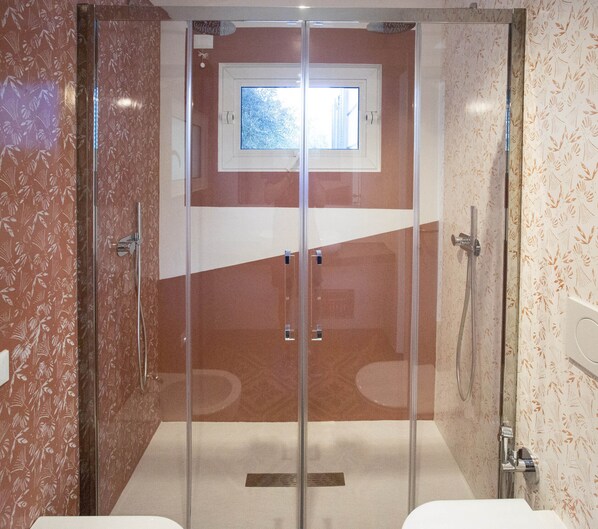 A modern bathroom with a glass shower enclosure, a toilet, and a sink. - Chiaror di Mare (Gaeta)